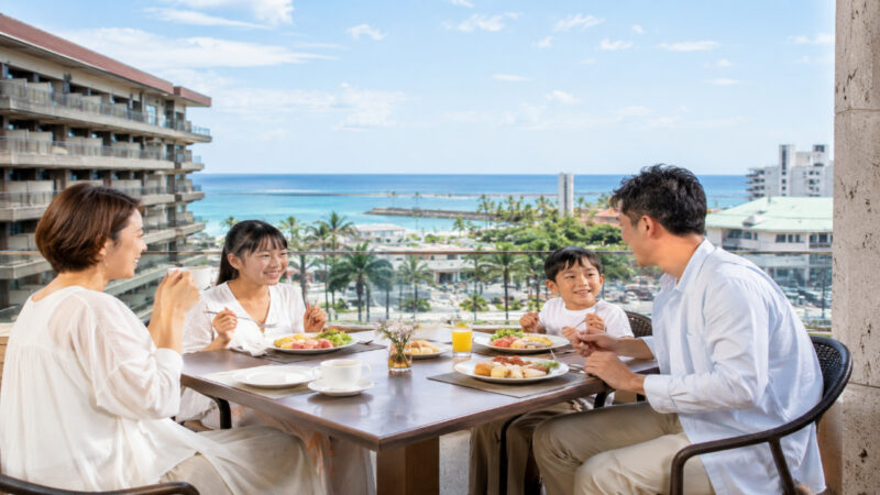 海が見えるリゾートホテルで朝食を楽しむ日本人家族の夏旅行風景