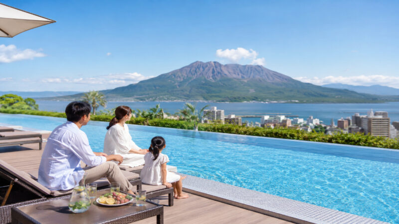 桜島を望む鹿児島のリゾートホテルプール脇で家族旅行を楽しむ日本人家族